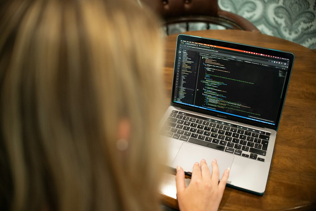 person coding on laptop