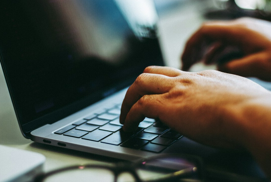 programmer typing on laptop