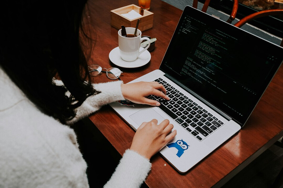 person typing code on laptop